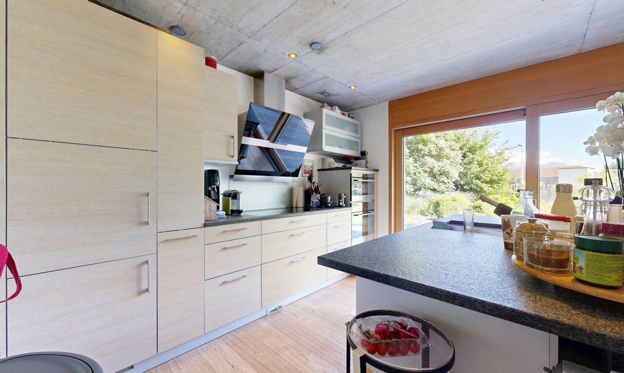 cuisine avec dark countertops, plans de travail, light floor, wood finish floor, et sol en finition bois