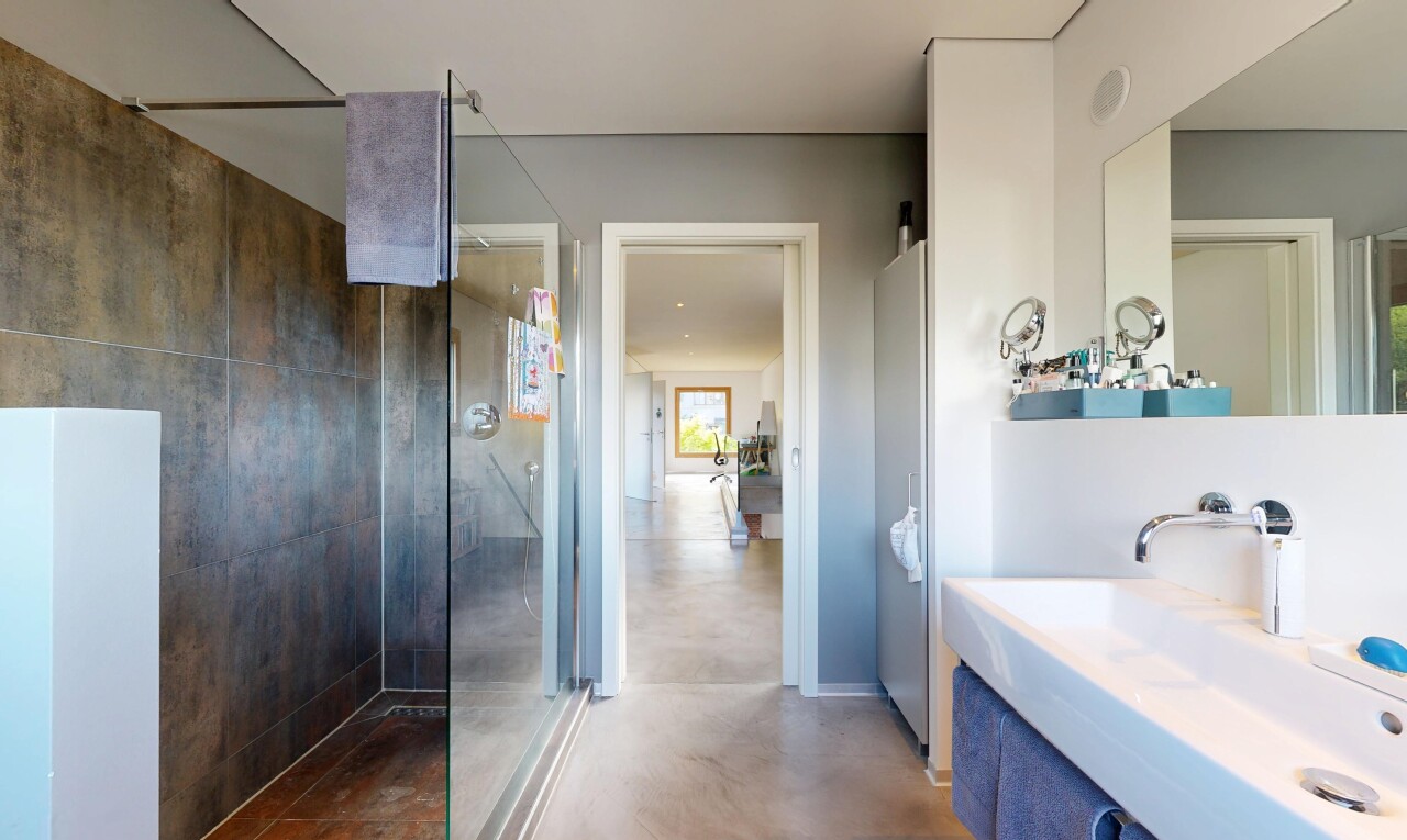 salle de bains avec douche, concrete floor, sol en béton, évier, et salle de bain complète