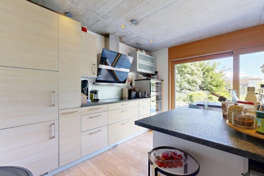 cuisine avec dark countertops, plans de travail, light floor, wood finish floor, et sol en finition bois