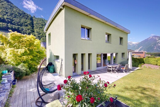 façade avec mountain view, vue sur la montagne, terrasse, bardage en stuc, et pelouse