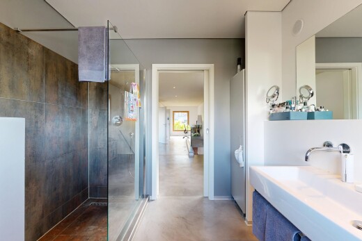 salle de bains avec douche, concrete floor, sol en béton, évier, et salle de bain complète