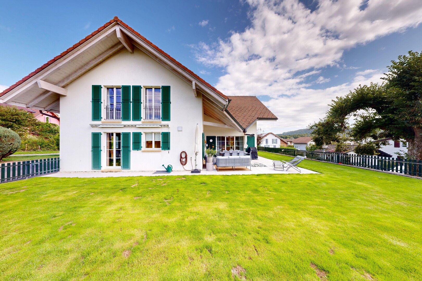 façade avec clôture, terrasse, property visible, bardage en stuc, et pelouse