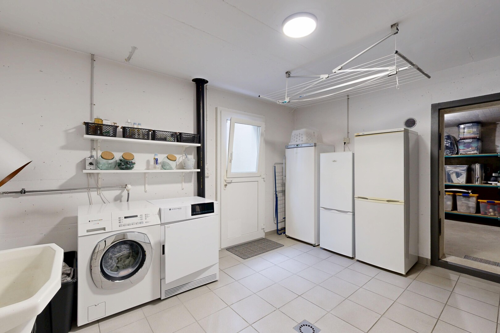 buanderie avec inside property, lave-linge et sèche-linge séparés, évier, cloison sèche, et drywall