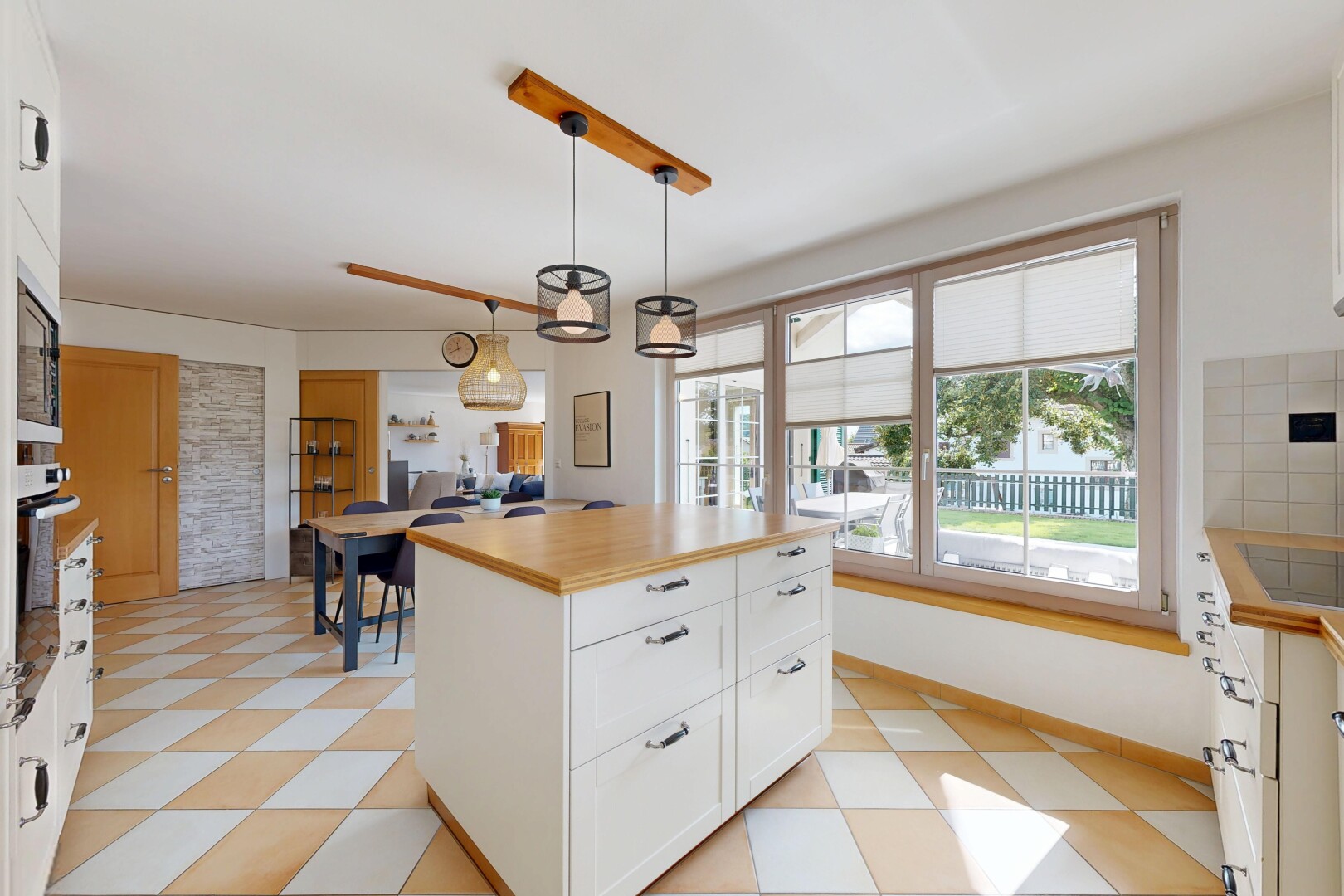cuisine avec armoires blanches, lumière naturelle, natural light, armoires de style shaker, et éclairage suspendu