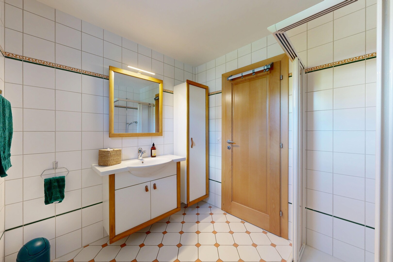 salle de bains avec mur en carrelage, tile wall, miroir, douche, et salle de bain complète