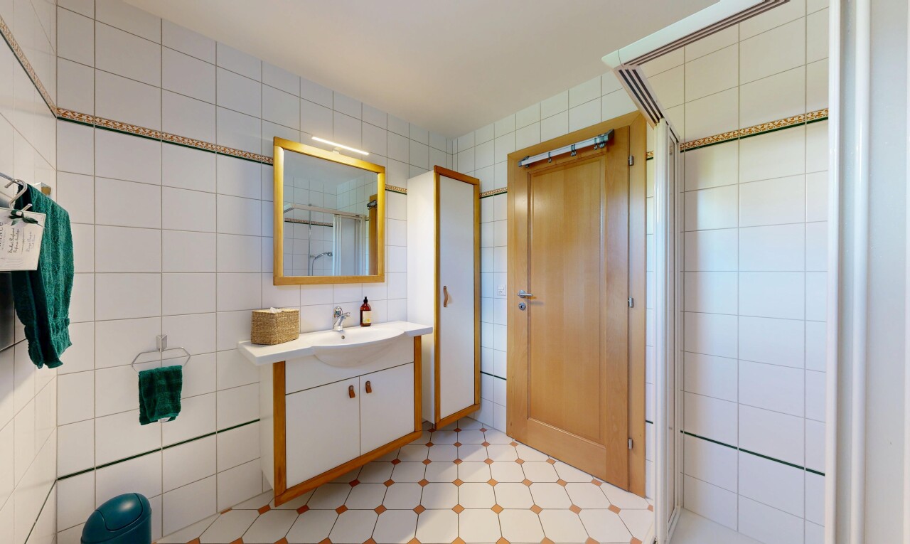 salle de bains avec mur en carrelage, tile wall, miroir, douche, et salle de bain complète