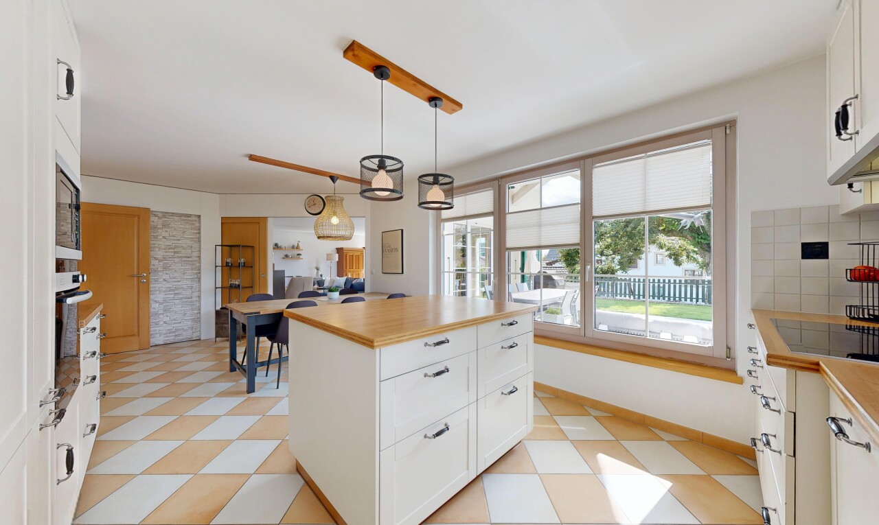 cuisine avec armoires blanches, lumière naturelle, natural light, armoires de style shaker, et éclairage suspendu
