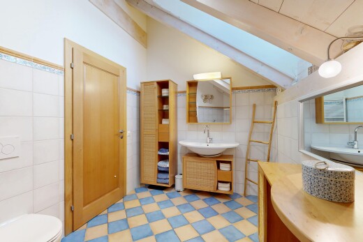 salle de bains avec sol en vinyle, vinyl floor, mur en carrelage, tile wall, et miroir