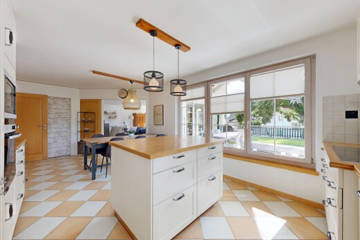 kitchen with white cabinets, hanging light fixtures, a center island, wall oven, and wood counters