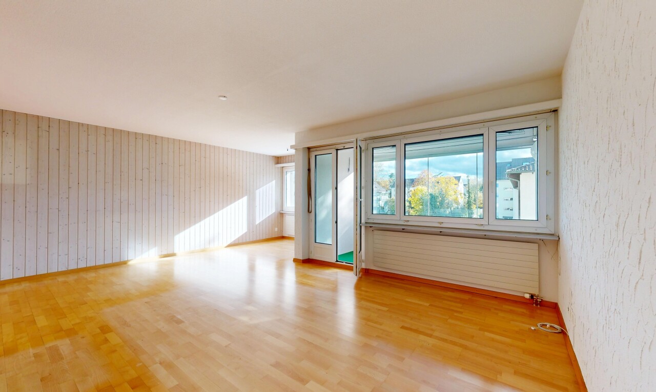 spare room featuring light wood-style floors, radiator heating unit, and wooden walls