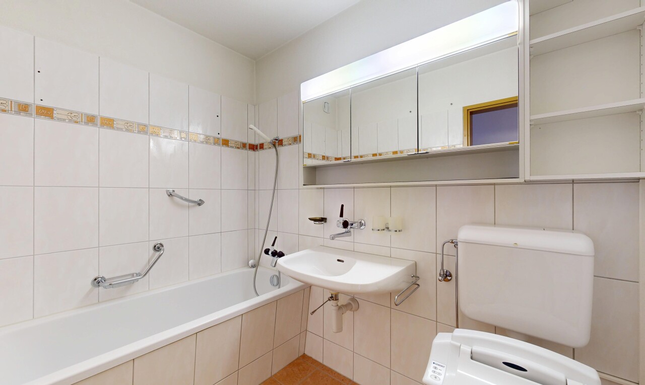 full bath with tile walls and a sink