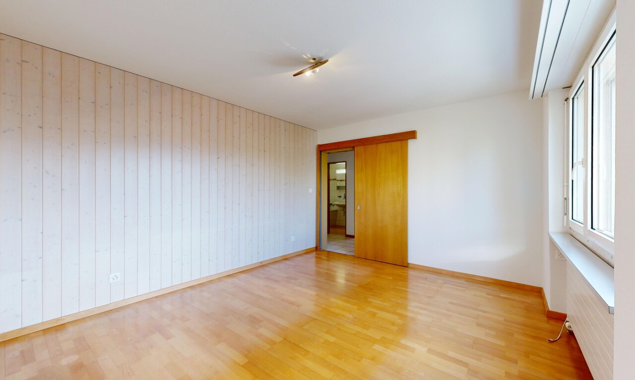 empty room with wood finished floors and wood walls