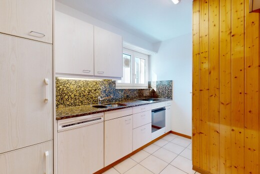 kitchen featuring tasteful backsplash, dishwashing machine, light tile patterned floors, and dark stone countertops