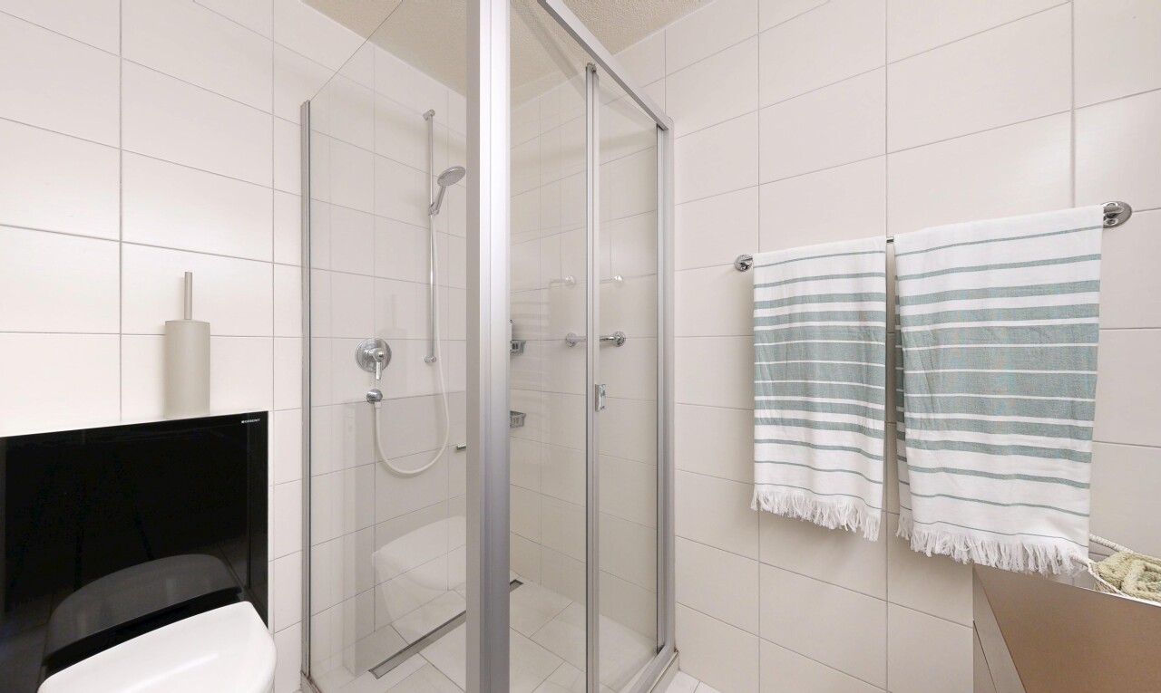 salle de bains avec salle de bain complète, toilette, douche, inside property, et mur en carrelage