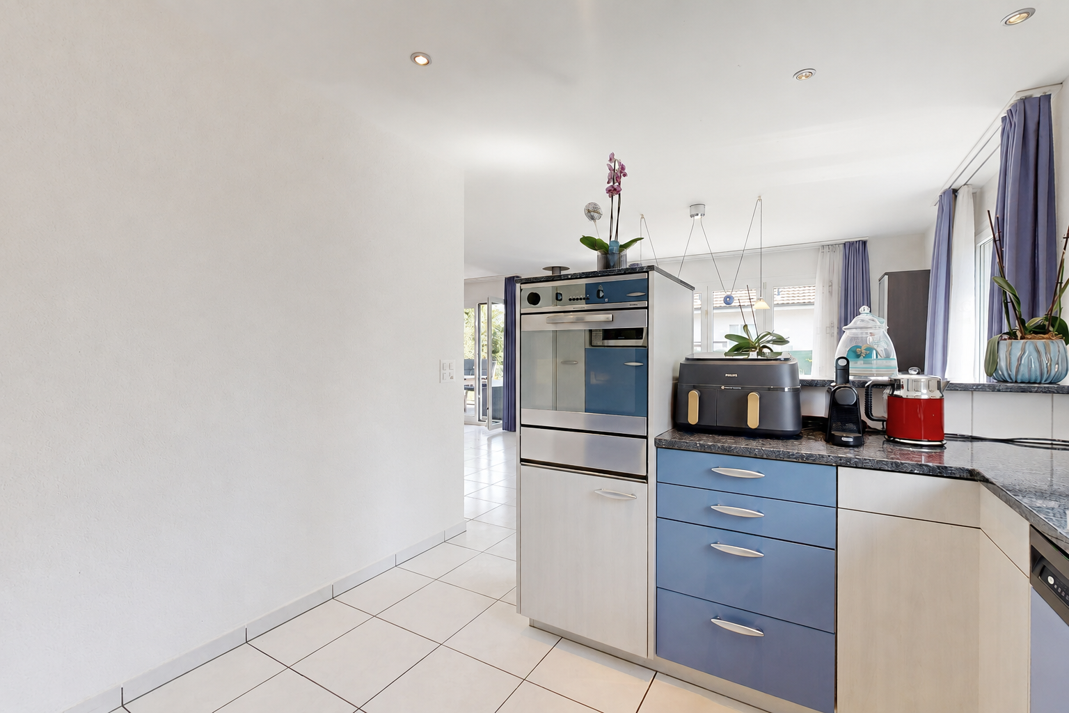 küche mit dark countertops, light floor, einbauleuchten, blue cabinets, und blaue schränke