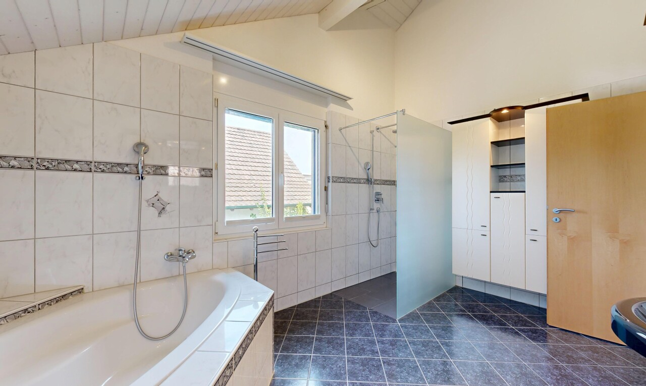 bad mit dusche, komplettes badezimmer, dark floor, dachschräge, und vaulted ceiling