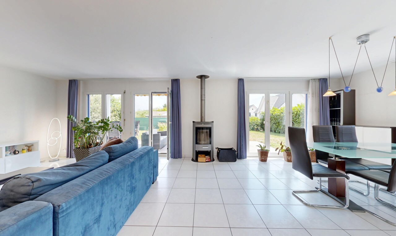 wohn- / esszimmer mit gipskartonwand, drywall, holzofen, fliesenboden, und tile floor