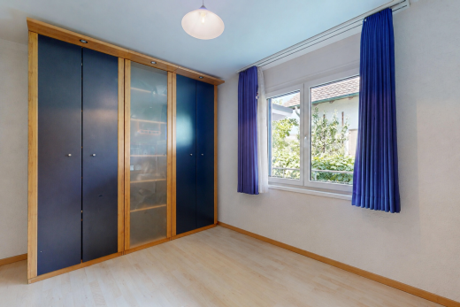 chambre avec wood finish floor, sol en finition bois, placard, light floor, et baseboards wall