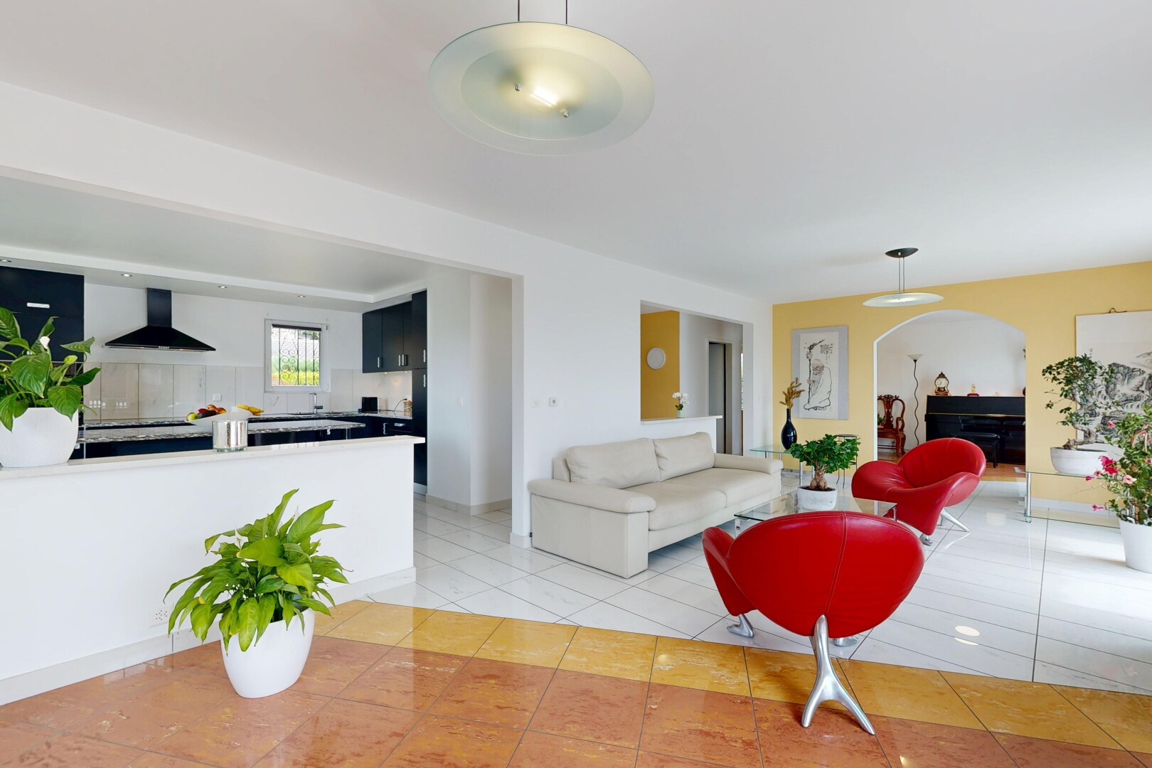 salon avec inside property, cloison sèche, drywall, passages en arc, et sol en carrelage