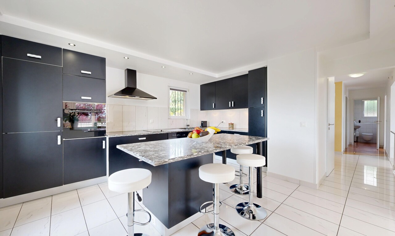 cuisine avec black cabinets, armoires noires, light floor, hotte, et backsplash