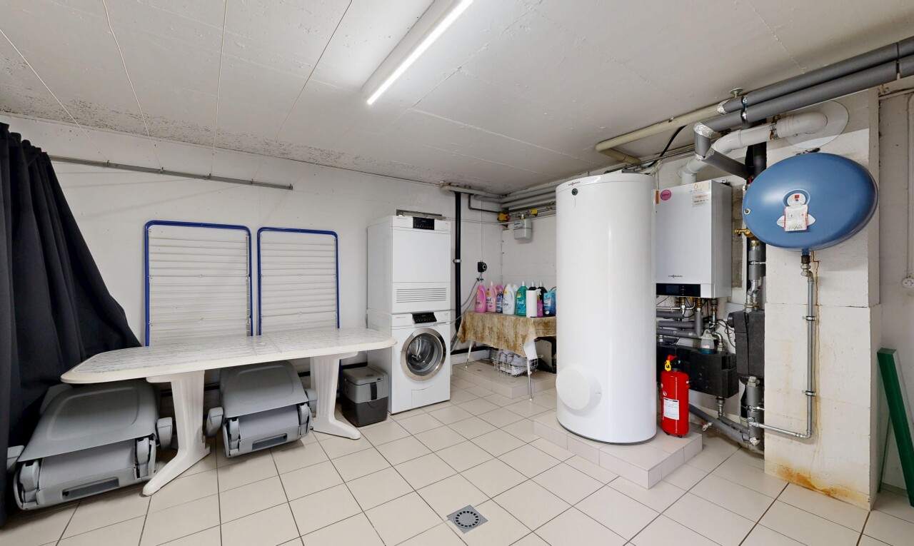 buanderie avec chauffe-eau, lave-linge et sèche-linge superposés, inside property, light floor, et réservoir d'expansion d'eau