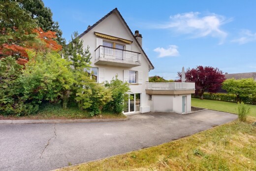 façade avec balcon, bardage en stuc, cheminée, property visible, et day time