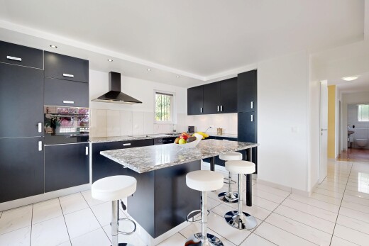 cuisine avec black cabinets, armoires noires, light floor, hotte, et backsplash