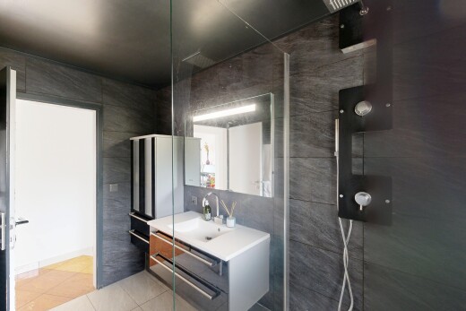 salle de bains avec mur en carrelage, tile wall, lavabo (ou coiffeuse selon le contexte), salle de bain complète, et sol en carrelage