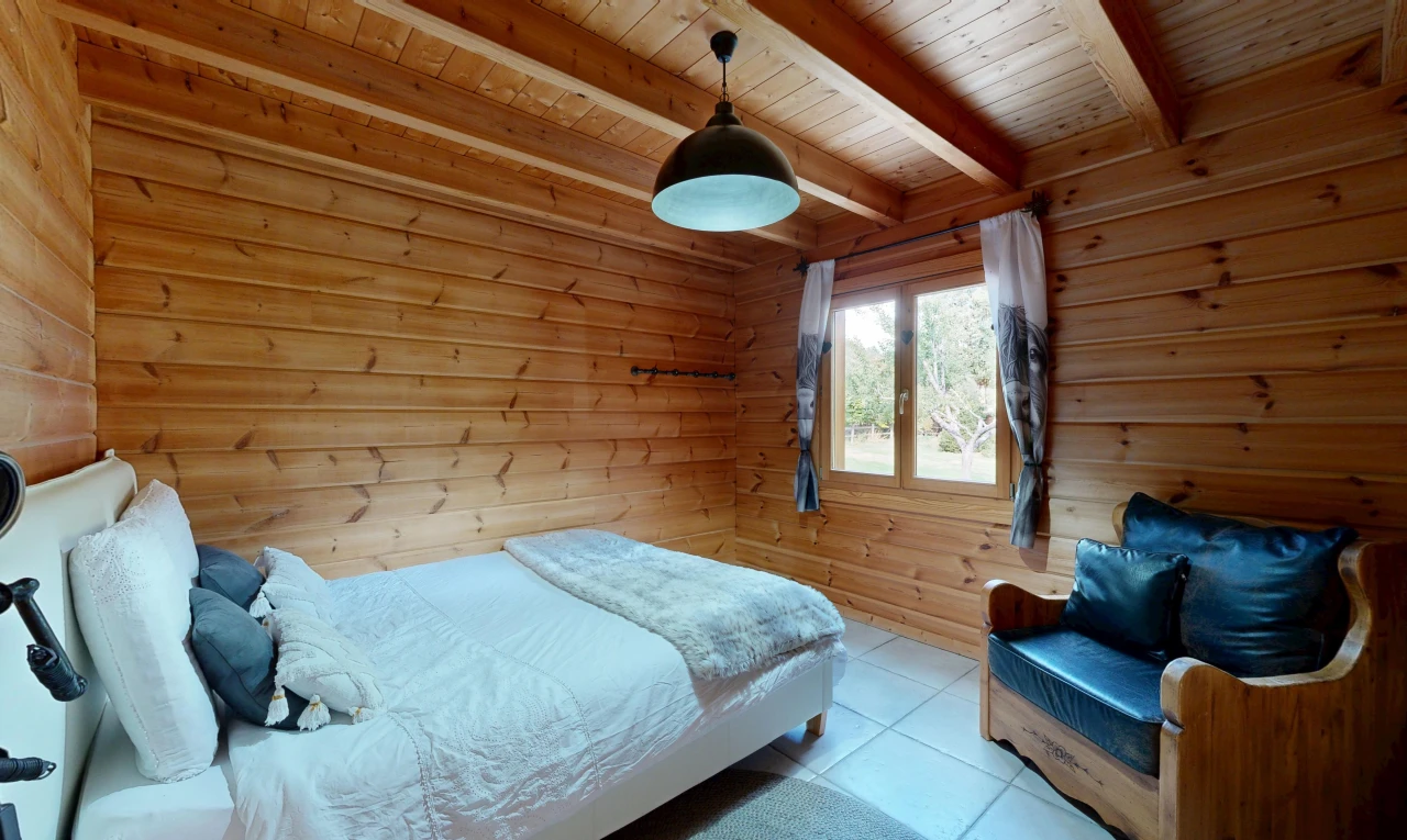 zimmer / schlafzimmer mit pendelleuchte, balkendecke, beamed ceiling, holzwand, und wood wall