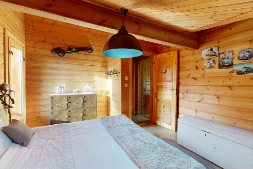 room featuring pendant lighting, wooden ceiling, and wooden walls