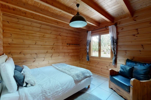 zimmer / schlafzimmer mit pendelleuchte, balkendecke, beamed ceiling, holzwand, und wood wall
