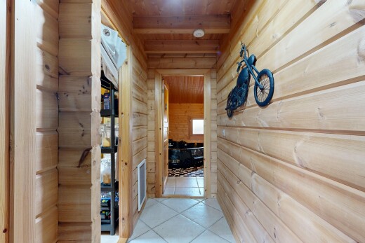 corridor with a relaxing sauna, wood walls, tile patterned floors, and wooden ceiling