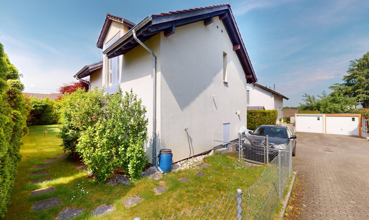 außenansicht mit property visible, stuckverkleidung, zaun, freistehende garage, und day time