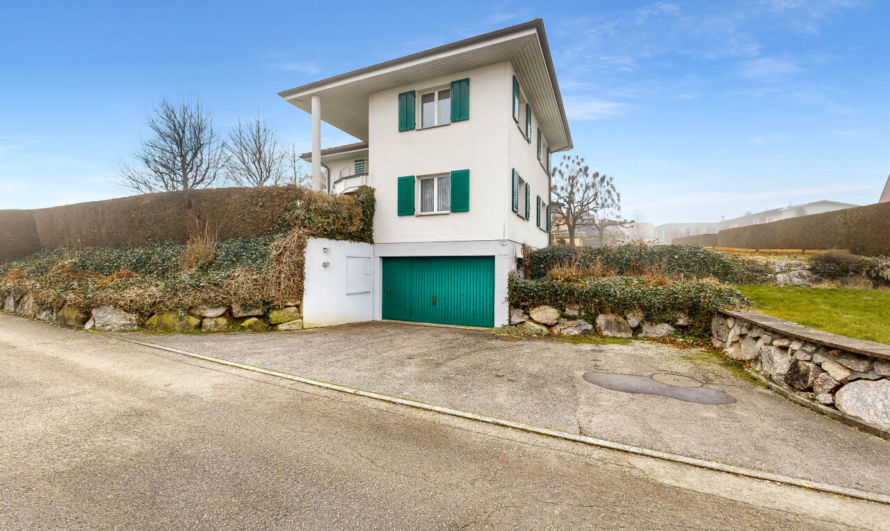 façade avec property visible, garage intégré, bardage en stuc, day time, et allée