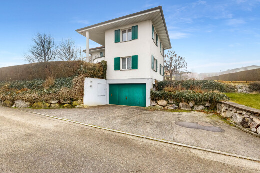 façade avec property visible, garage intégré, bardage en stuc, day time, et allée