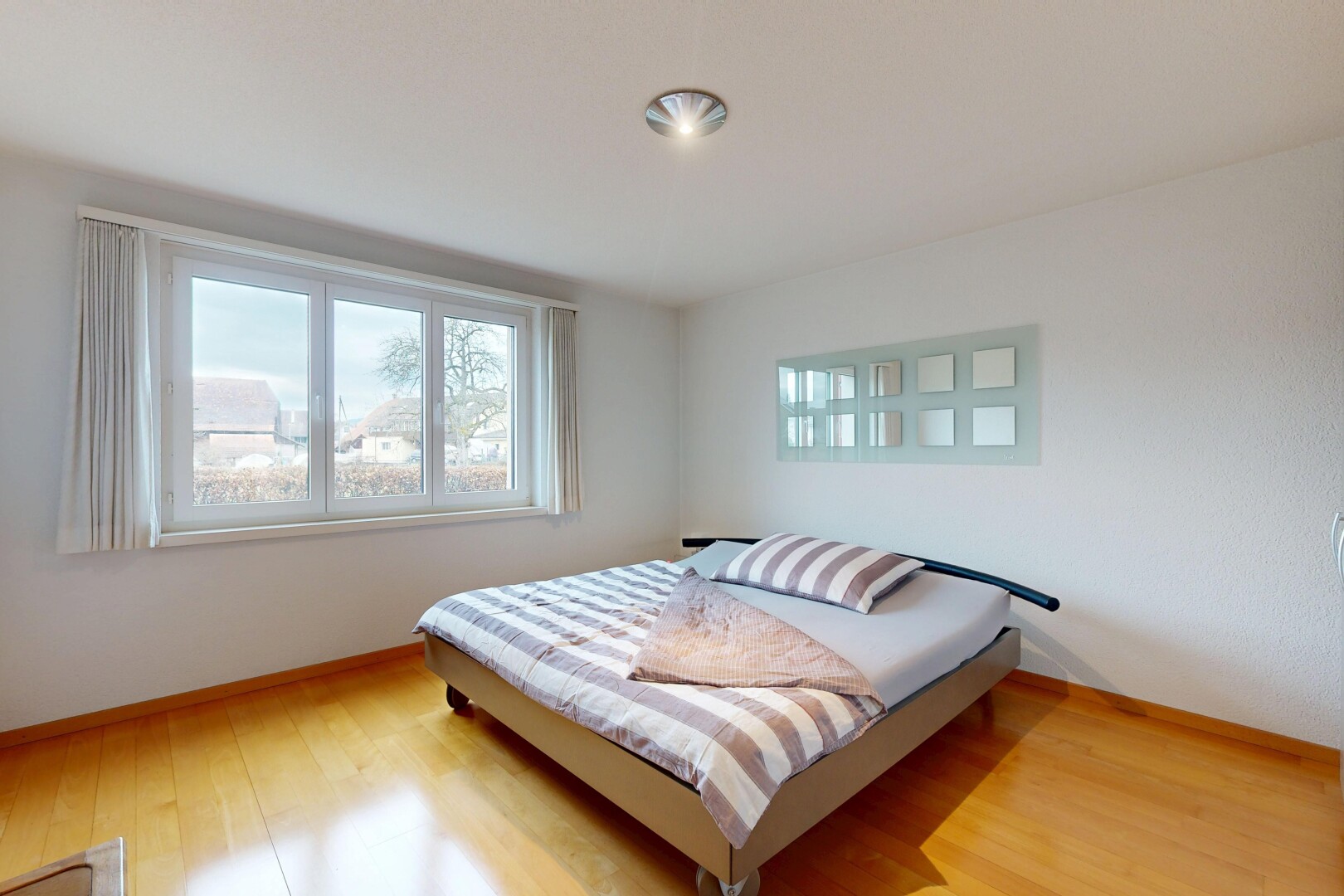 chambre avec sol en finition bois, wood finish floor, inside property, lumière naturelle, et natural light