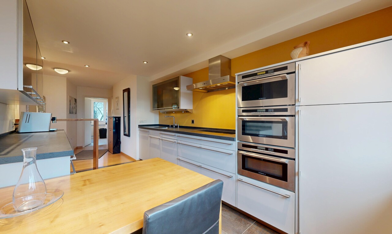 cuisine avec hotte, four double, armoires blanches, inside property, et micro-ondes
