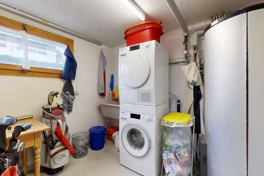buanderie avec lave-linge et sèche-linge superposés, inside property, buanderie, sol en béton, et concrete floor