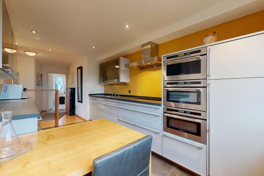 cuisine avec hotte, four double, armoires blanches, inside property, et micro-ondes