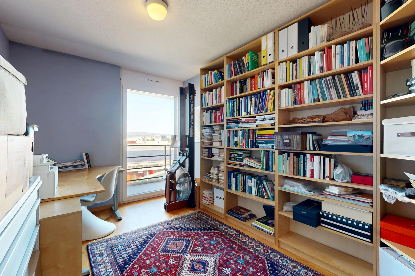 büro mit eingebaute regale, eingebauter schreibtisch, holzfußboden, wood finish floor, und inside property