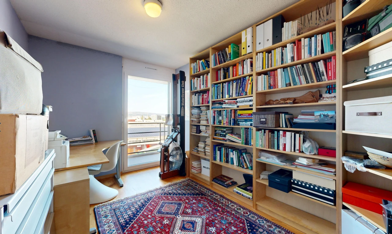 büro mit eingebaute regale, eingebauter schreibtisch, holzfußboden, wood finish floor, und inside property