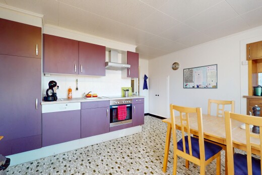 cuisine avec plan de travail, cuisinière, hotte, four, et lave-vaisselle