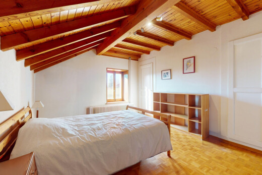 chambre avec plafond de bois, lumière naturelle, radiateur, poutres apparentes, et parquet