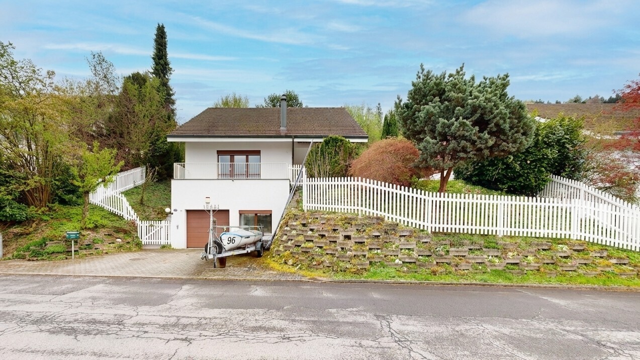 außenansicht mit zaun, balkon, eingebaute garage, auffahrt, und property visible
