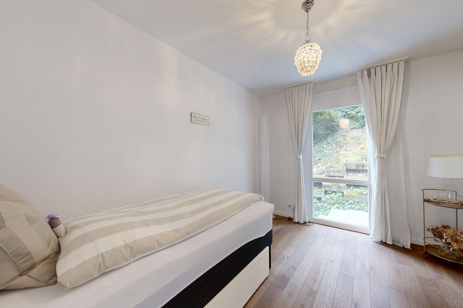 zimmer / schlafzimmer mit gipskartonwand, drywall, holzfußboden, wood finish floor, und natürliches licht