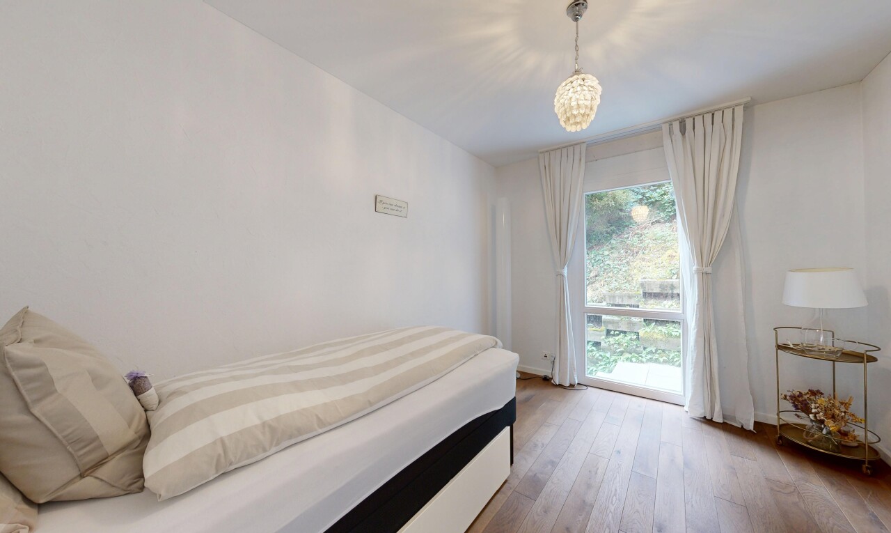 zimmer / schlafzimmer mit gipskartonwand, drywall, holzfußboden, wood finish floor, und natürliches licht
