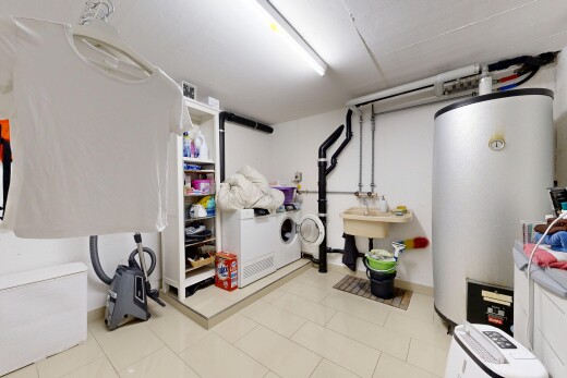 buanderie avec light floor, chauffe-eau, inside property, cloison sèche, et drywall