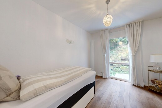 zimmer / schlafzimmer mit gipskartonwand, drywall, holzfußboden, wood finish floor, und natürliches licht