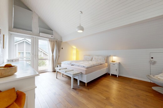 chambre avec accès à l'extérieur, sol en finition bois, wood finish floor, plafond voûté, et vaulted ceiling