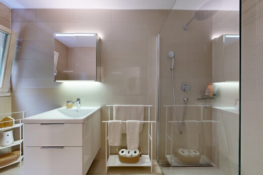 salle de bains avec lavabo (ou coiffeuse selon le contexte), mur en carrelage, tile wall, miroir, et douche